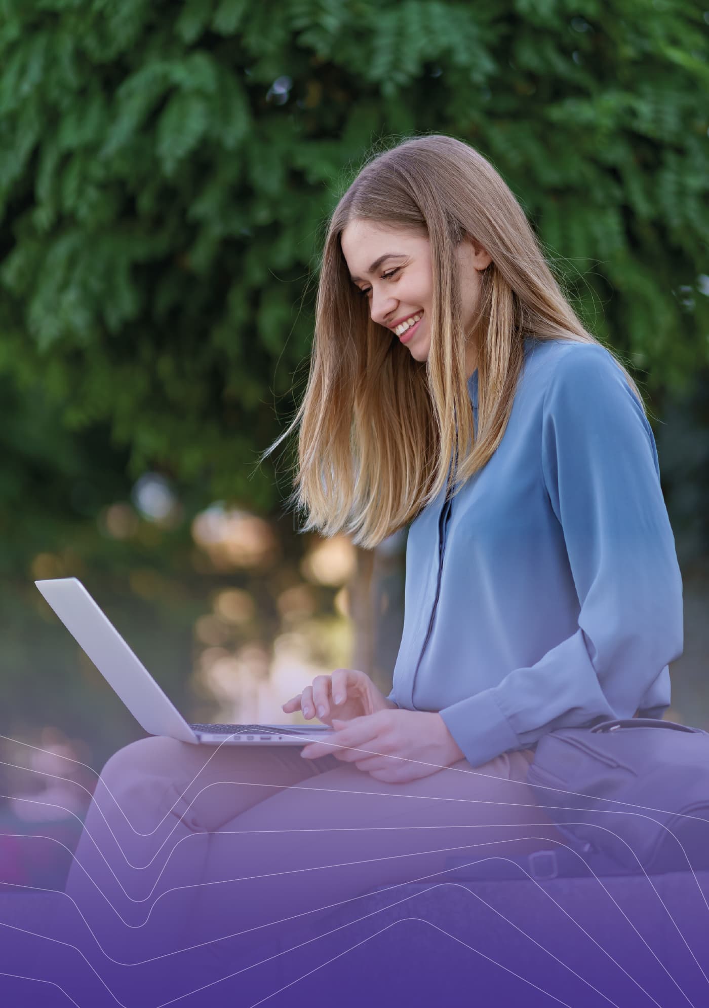 A student working on a laptop outdoors
